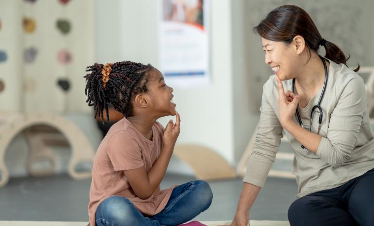 A speech language therapist working with a child.