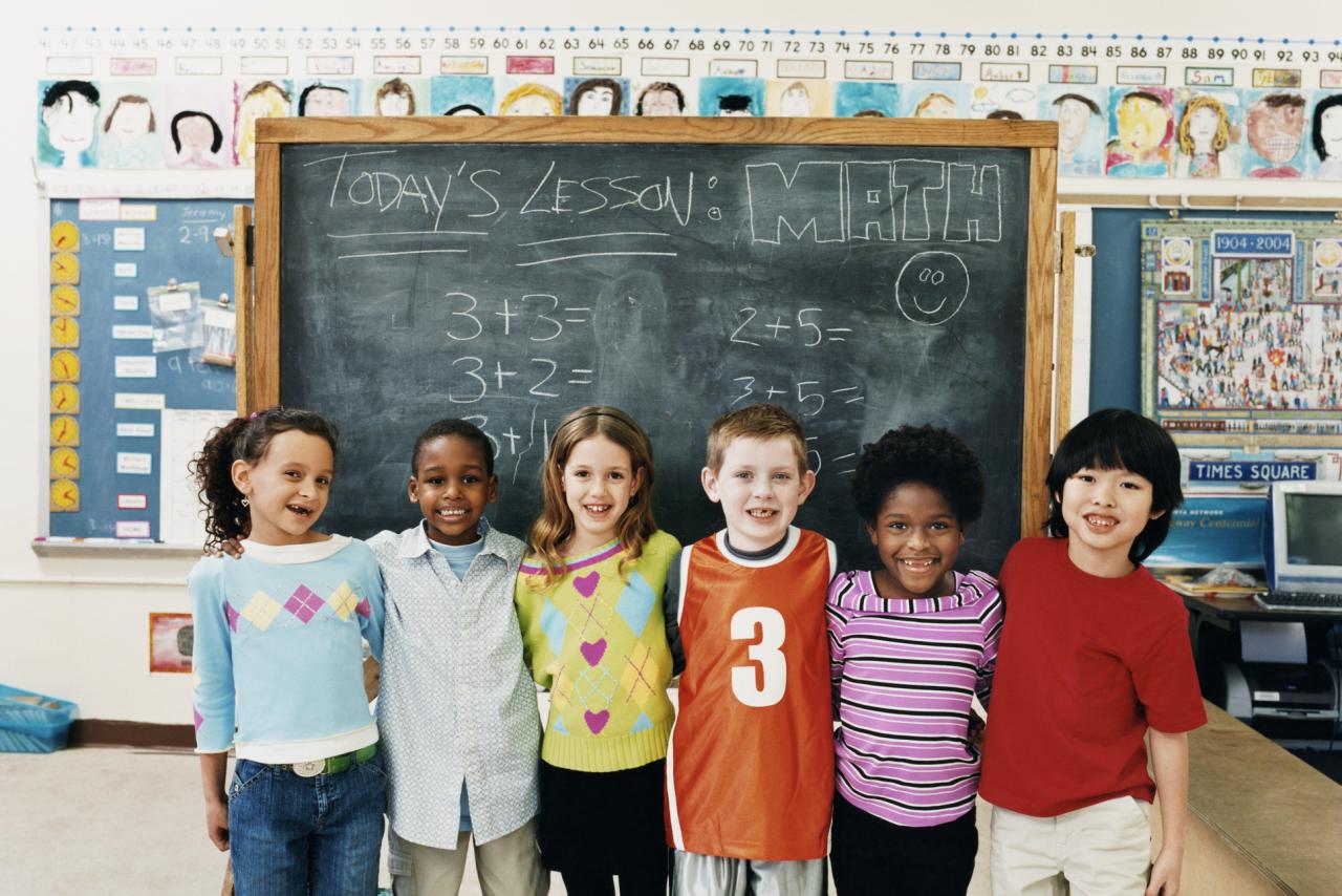 Five smiling children inside a classroom