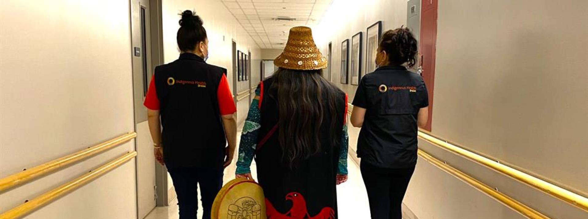 Three Indigenous Patient Navigators walking down a hallway at Vancouver General Hospital 