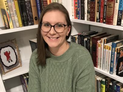 Alyssa Dixon, SLP, sitting in front of a bookshelf.