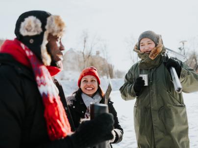 a diverse group having hot coco outside during winter